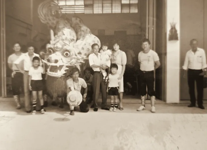 The family and lion dance troupe at the opening of the first factory in Tampines, 1980s