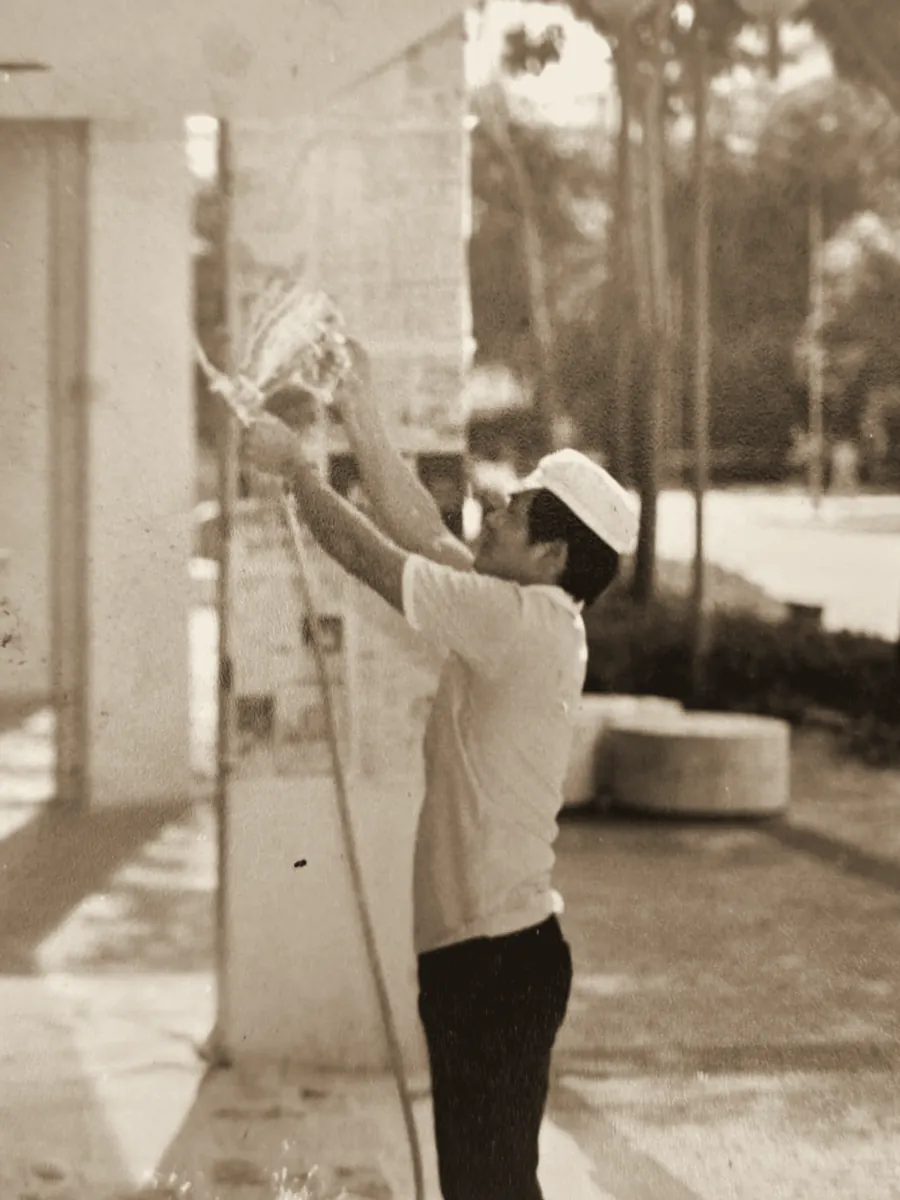 Mr Tian Ming spray-coating a void deck column, 1980s